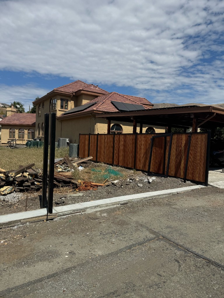 Custom sliding gate with iron frame and wood fence panels in Fremont
